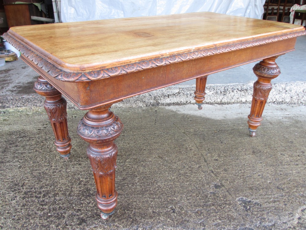 Victorian carved oak dining table with bulbous carved and tapering fluted legs on castors