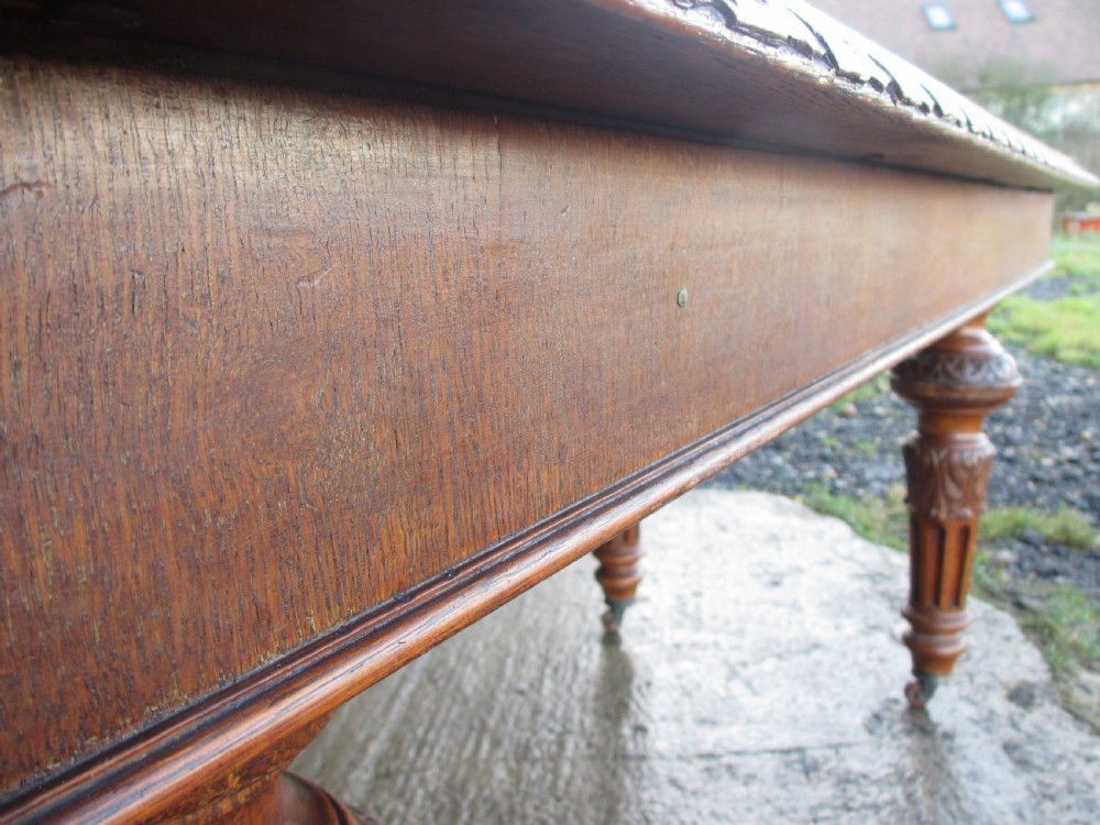 Victorian carved oak dining table with bulbous carved and tapering fluted legs on castors View V