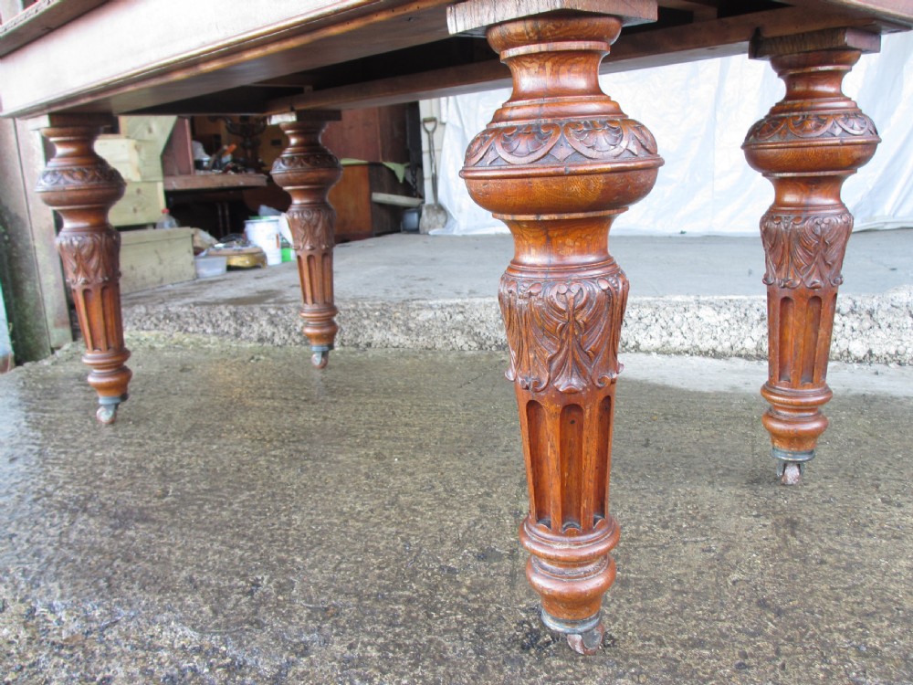 Victorian carved oak dining table with bulbous carved and tapering fluted legs on castors View VI