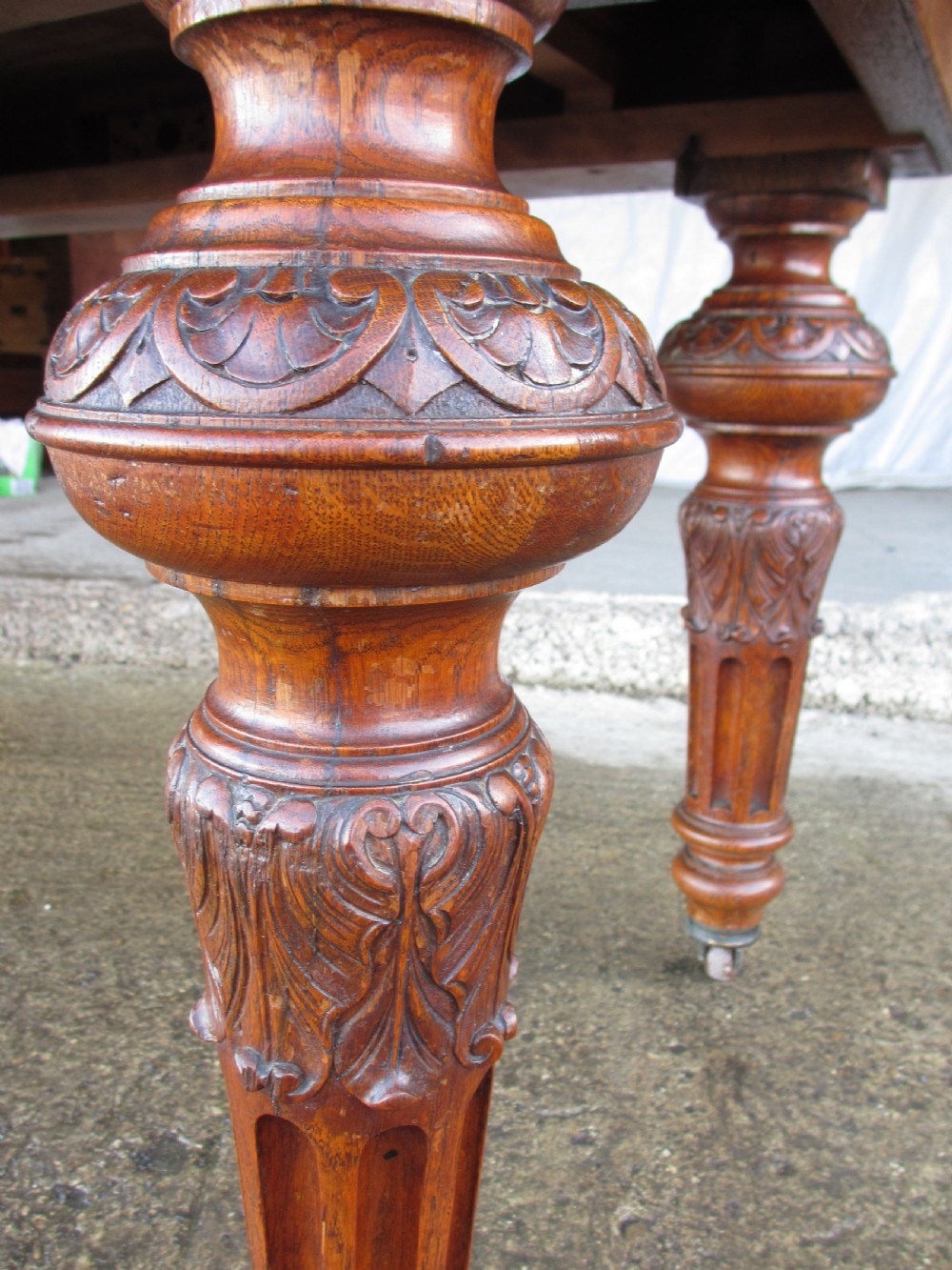 Victorian carved oak dining table with bulbous carved and tapering fluted legs on castors View VII