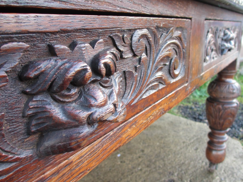 Victorian carved oak green man library writing desk twin drawers carved legs on castors with stops View VIII