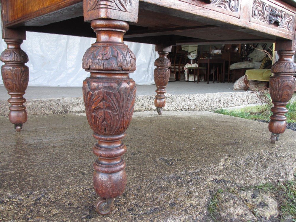 Victorian carved oak green man library writing desk twin drawers carved legs on castors with stops View X