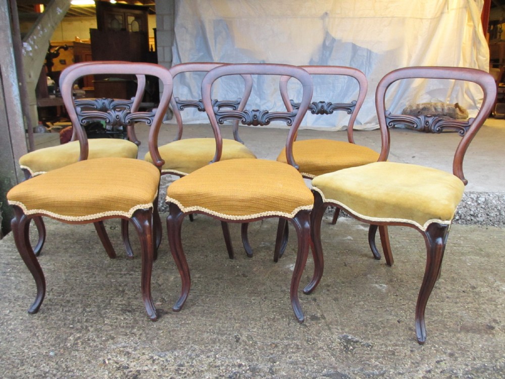 A set of six Victorian rosewood balloon back dining chairs with carved waist rails, yellow upholstered serpentine seats, and cabriole legs. View III