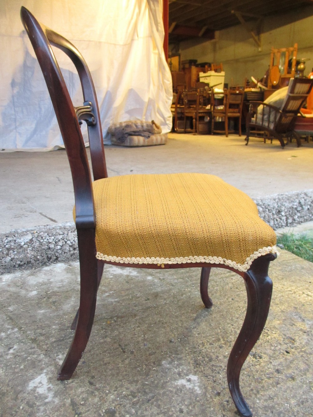 A set of six Victorian rosewood balloon back dining chairs with carved waist rails, yellow upholstered serpentine seats, and cabriole legs. View XII