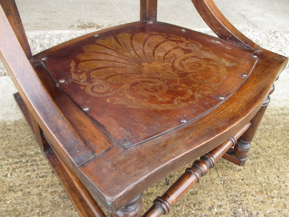 A Victorian oak and beech rocking chair featuring turned spindles, a carved shell pattern on the backrest and seat, and decorative metal studs. View VI