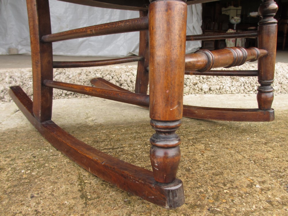 A Victorian oak and beech rocking chair featuring turned spindles, a carved shell pattern on the backrest and seat, and decorative metal studs. View IX