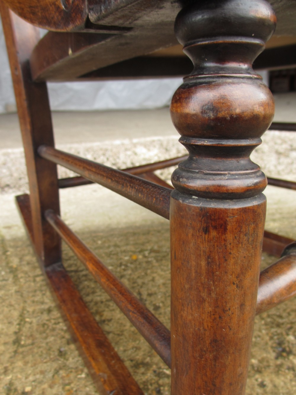 A Victorian oak and beech rocking chair featuring turned spindles, a carved shell pattern on the backrest and seat, and decorative metal studs. View X