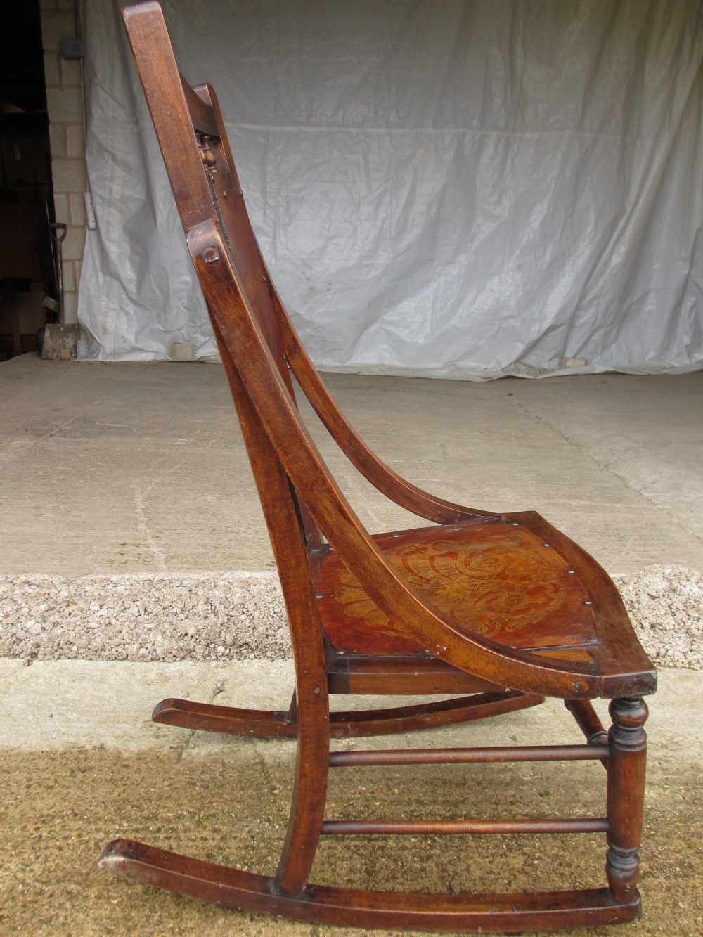 A Victorian oak and beech rocking chair featuring turned spindles, a carved shell pattern on the backrest and seat, and decorative metal studs. View XI