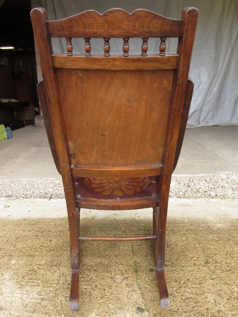 A Victorian oak and beech rocking chair featuring turned spindles, a carved shell pattern on the backrest and seat, and decorative metal studs. View XII