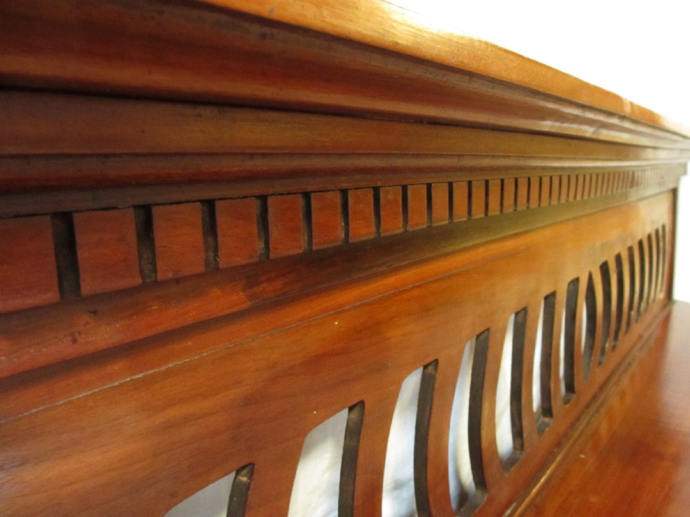 A Victorian mahogany triptych overmantel mirror featuring three glass panels, a fretted top frieze with crescent cut-outs, decorative side brackets, and a moulded cornice. View VI