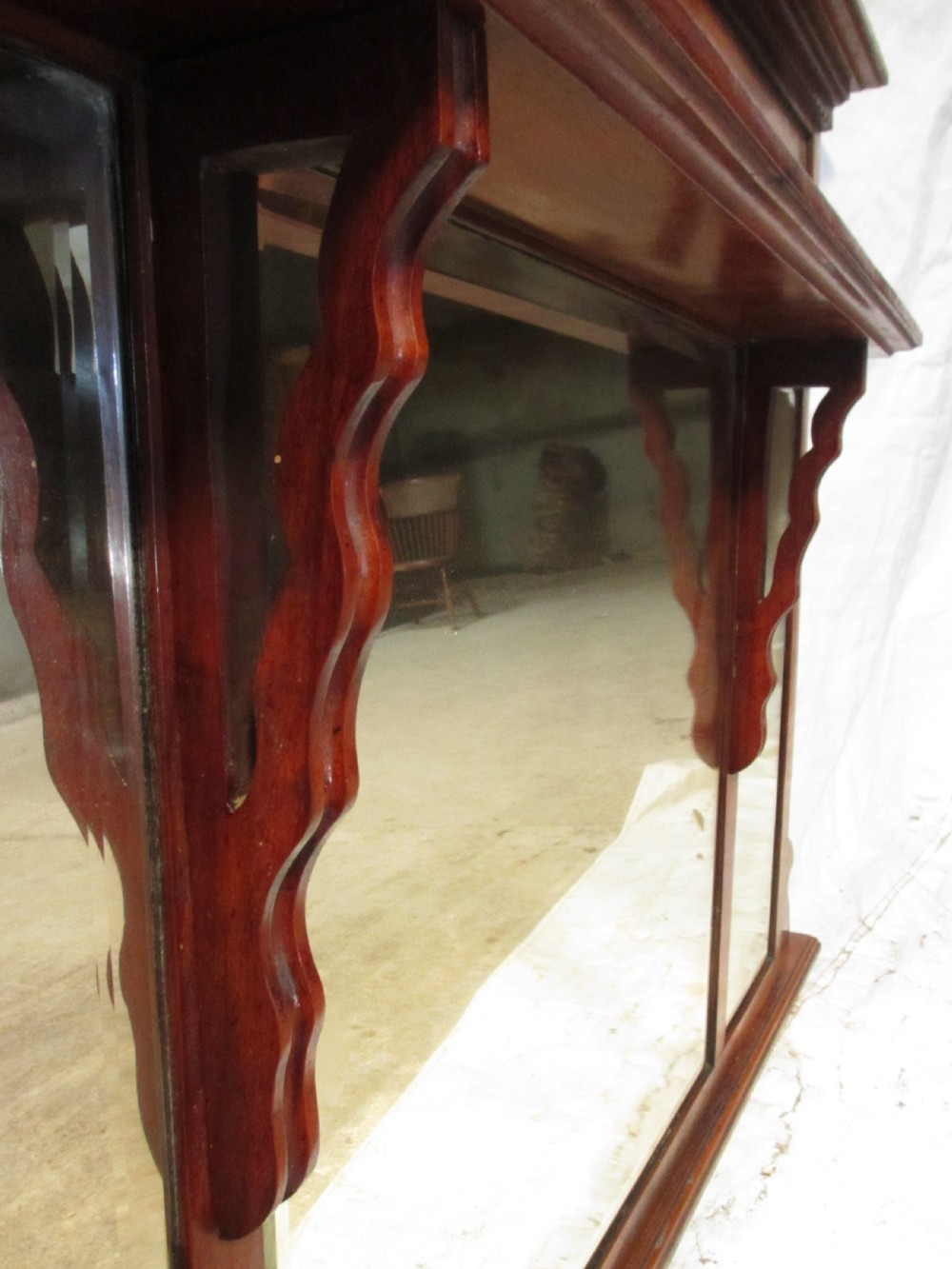 A Victorian mahogany triptych overmantel mirror featuring three glass panels, a fretted top frieze with crescent cut-outs, decorative side brackets, and a moulded cornice. View VII