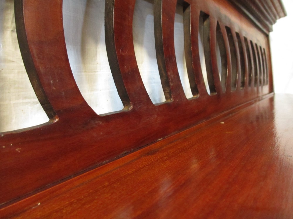 A Victorian mahogany triptych overmantel mirror featuring three glass panels, a fretted top frieze with crescent cut-outs, decorative side brackets, and a moulded cornice. View IX