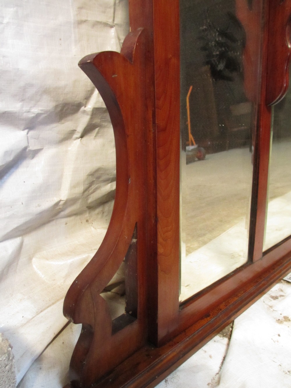 A Victorian mahogany triptych overmantel mirror featuring three glass panels, a fretted top frieze with crescent cut-outs, decorative side brackets, and a moulded cornice. View X