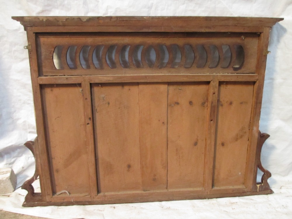 A Victorian mahogany triptych overmantel mirror featuring three glass panels, a fretted top frieze with crescent cut-outs, decorative side brackets, and a moulded cornice. View XII