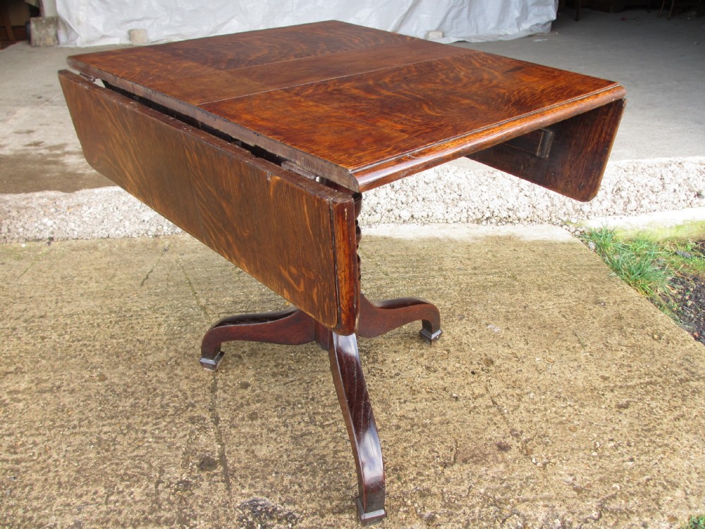 A Victorian dark oak drop-leaf breakfast table featuring a rectangular surface with grain figure, a turned central pedestal stem, and splayed legs. View III