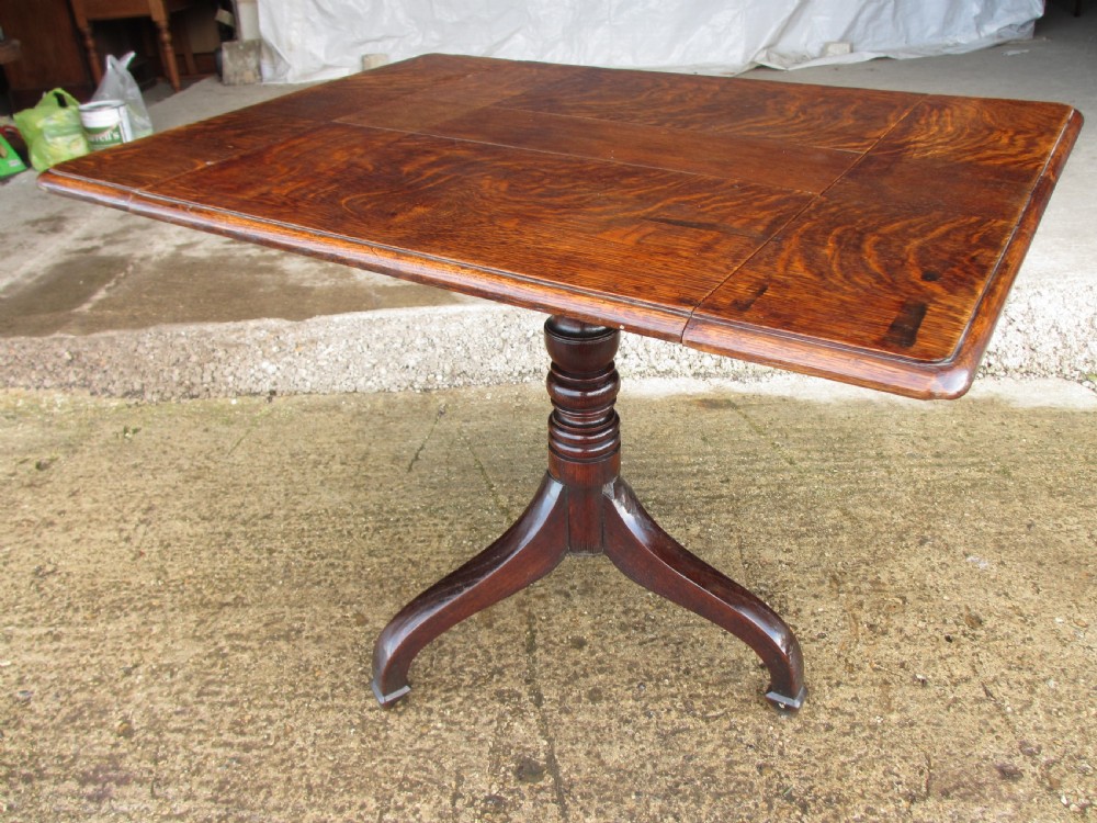 A Victorian dark oak drop-leaf breakfast table featuring a rectangular surface with grain figure, a turned central pedestal stem, and splayed legs. View VI