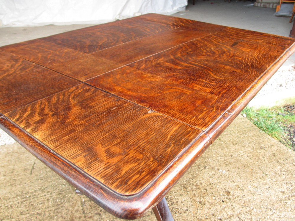 A Victorian dark oak drop-leaf breakfast table featuring a rectangular surface with grain figure, a turned central pedestal stem, and splayed legs. View VII