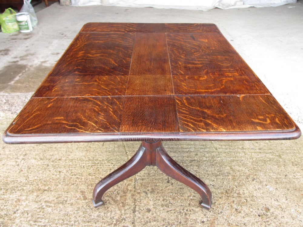 A Victorian dark oak drop-leaf breakfast table featuring a rectangular surface with grain figure, a turned central pedestal stem, and splayed legs. View XI