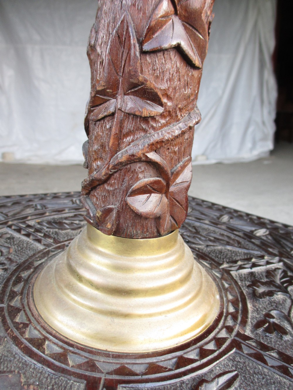 A Victorian Anglo-Burmese carved padouk wood and brass floor oil lamp with mythical dragon legs, a carved column, a brass reservoir, and a white glass shade. View V