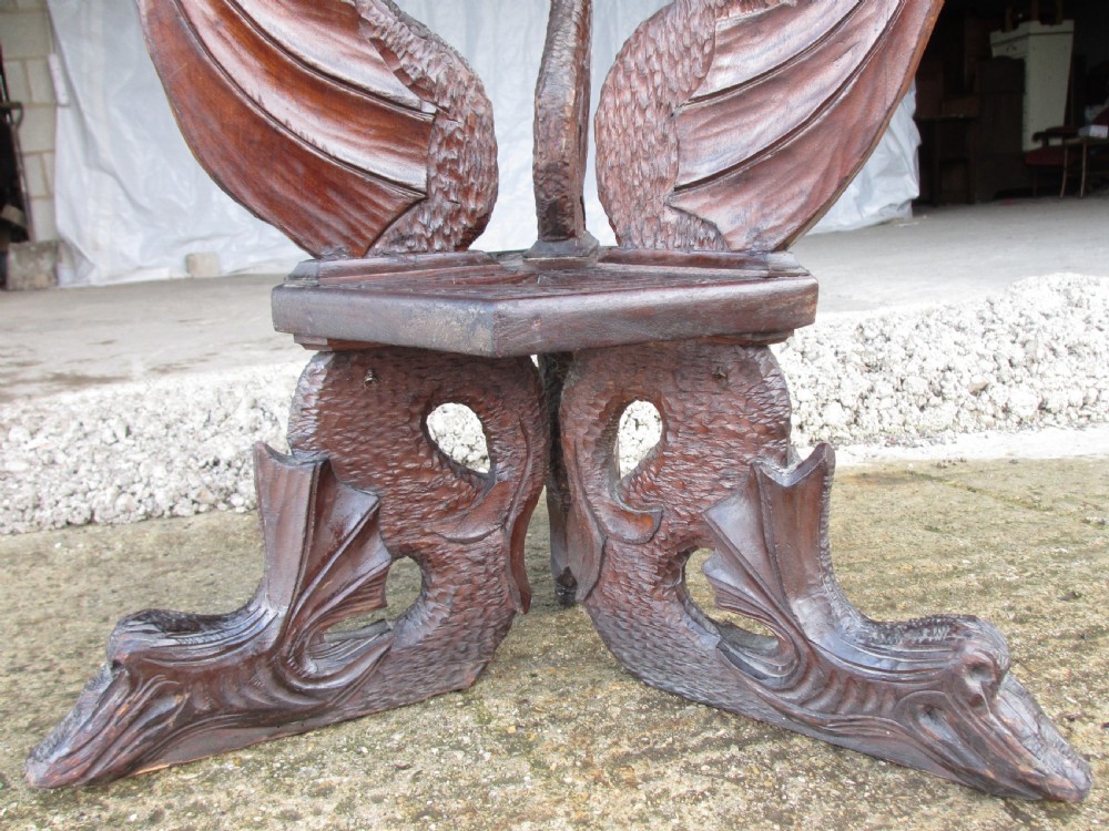 A Victorian Anglo-Burmese carved padouk wood and brass floor oil lamp with mythical dragon legs, a carved column, a brass reservoir, and a white glass shade. View XII