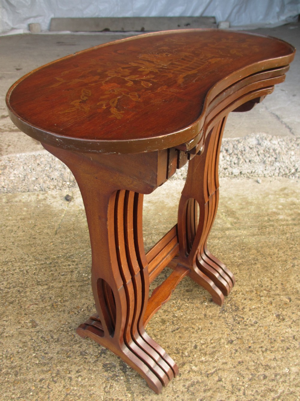 A set of four nested mahogany side tables featuring kidney-shaped tops with floral marquetry inlay. View II
