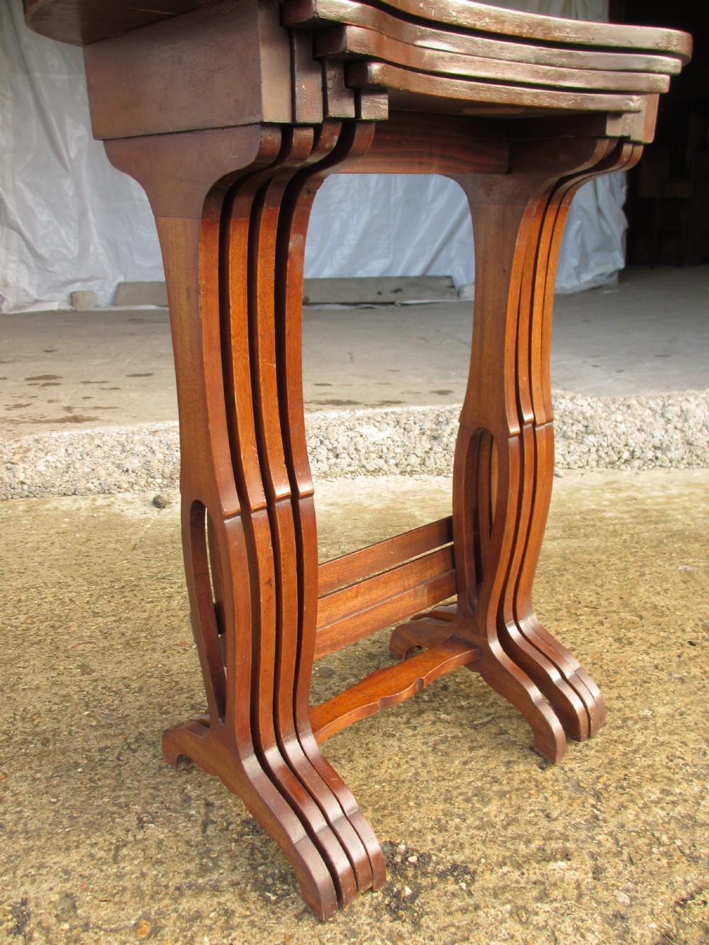 A set of four nested mahogany side tables featuring kidney-shaped tops with floral marquetry inlay. View VII
