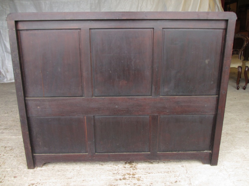 A dark mahogany panelled box settle featuring carved lozenge motifs on the backrest and foliate carving on the front panels. View XII