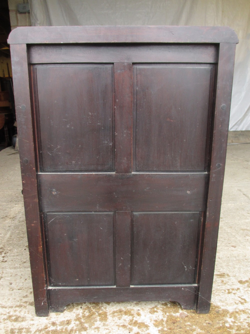 A dark brown carved mahogany box settle featuring a high panelled back with diamond motifs, curved armrests, and a hinged storage base decorated with foliate carvings. View XII