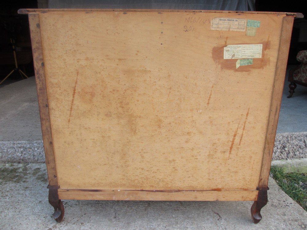 A warm brown mahogany chest of drawers featuring five drawers with brass handles and curved cabriole legs. View XII