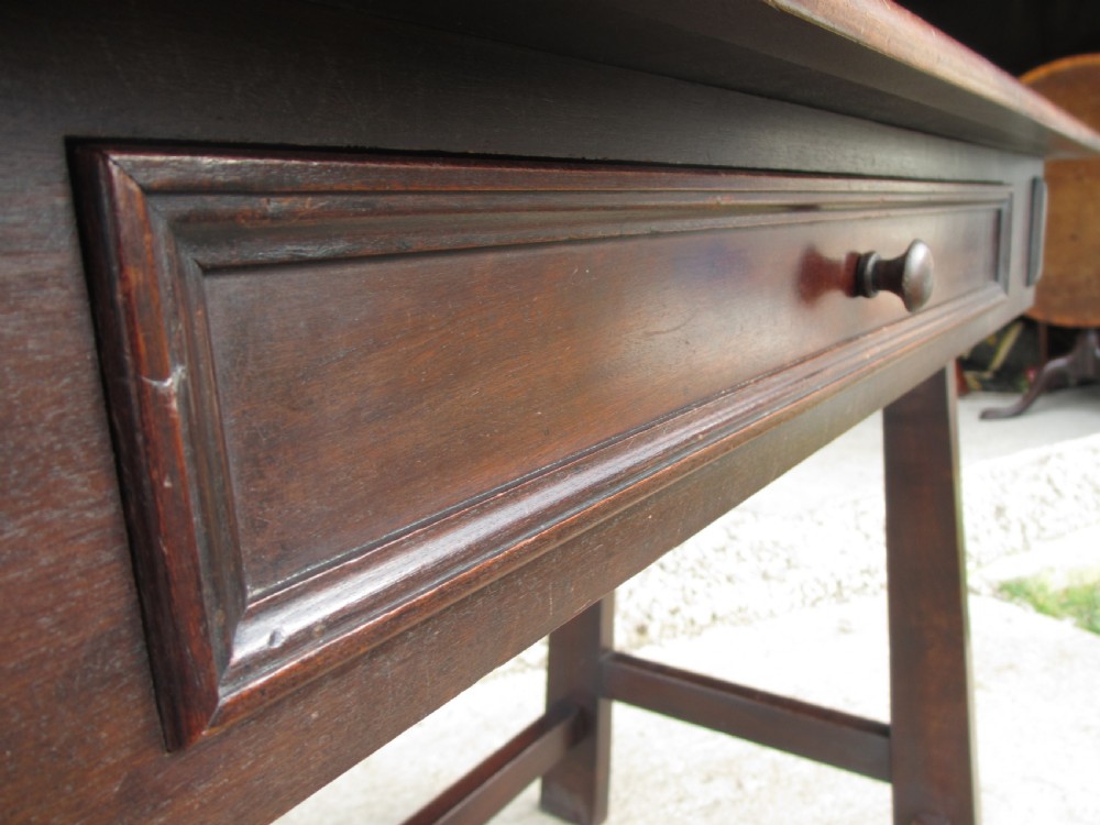 A dark mahogany wooden side table featuring a single frieze drawer with a wooden knob handle and lower cross stretchers. View VI