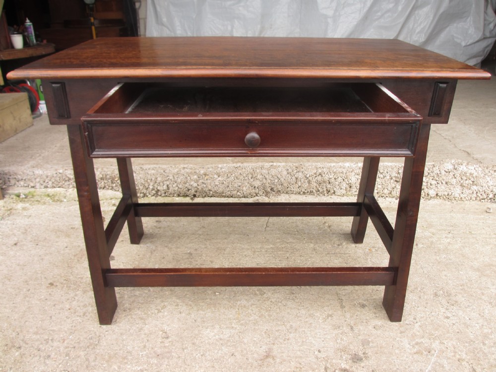 A dark mahogany wooden side table featuring a single frieze drawer with a wooden knob handle and lower cross stretchers. View X