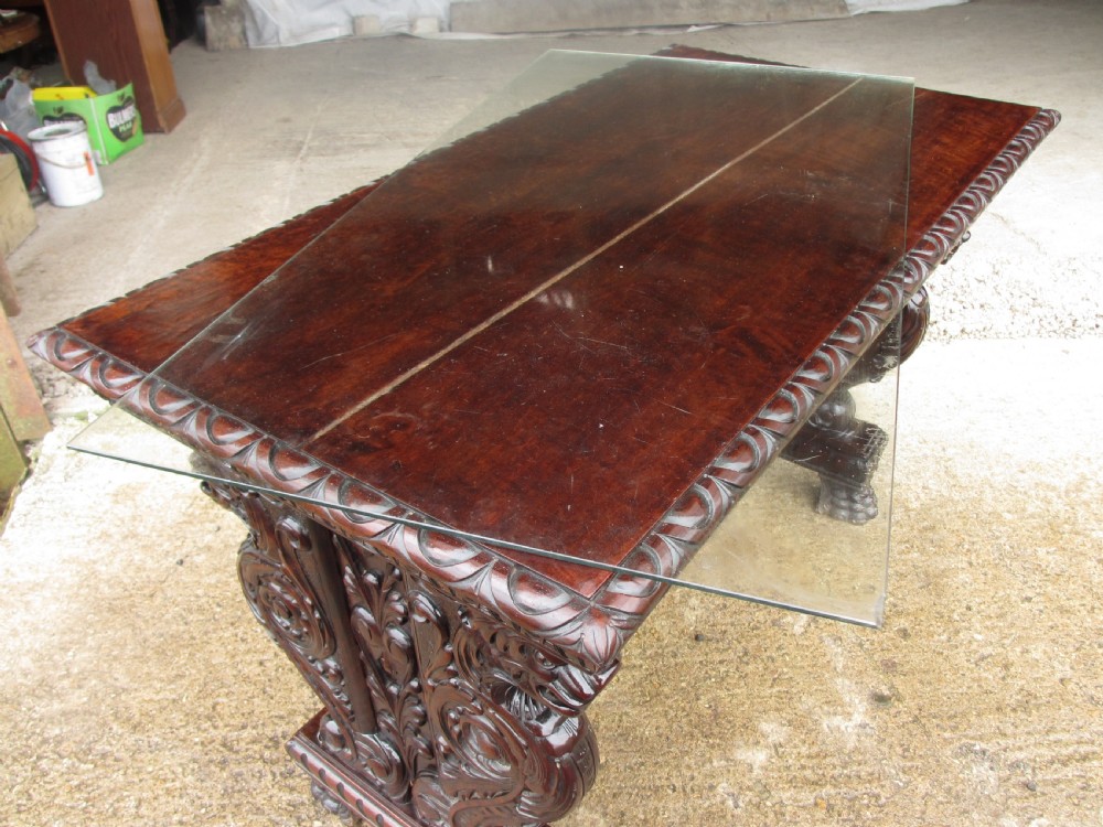 Carved dark mahogany centre console table featuring scroll supports with carved grotesque figures, a decorated stretcher, and claw feet. View IV