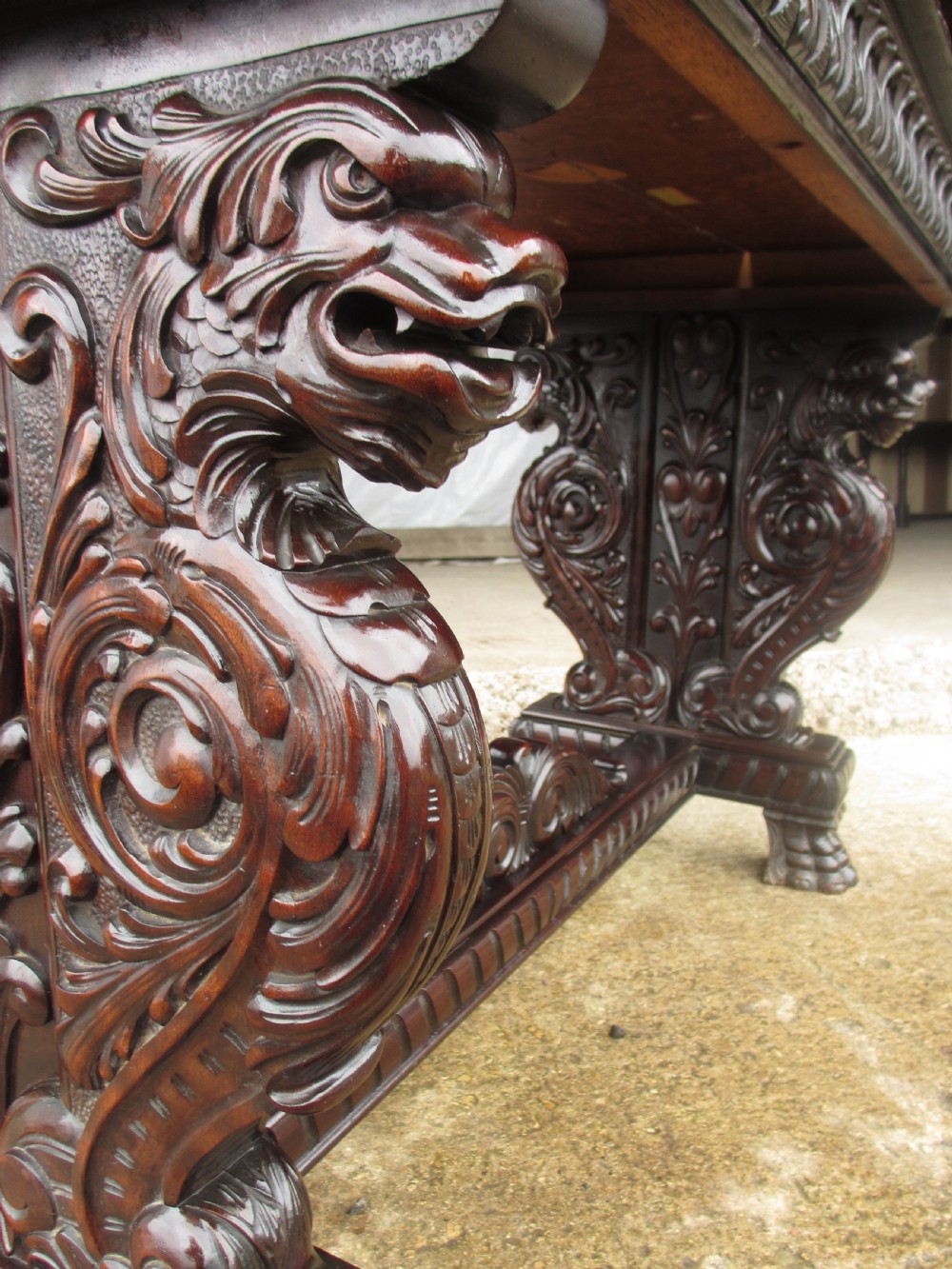 Carved dark mahogany centre console table featuring scroll supports with carved grotesque figures, a decorated stretcher, and claw feet. View VI