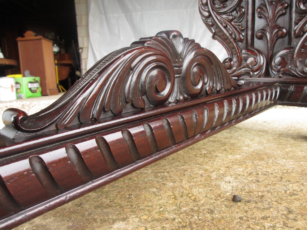 Carved dark mahogany centre console table featuring scroll supports with carved grotesque figures, a decorated stretcher, and claw feet. View IX
