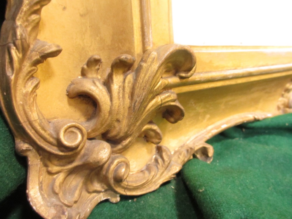 A rectangular gold gilt frame with ornate scroll detailing containing a monochrome portrait drawing of a mother and daughter. View VII