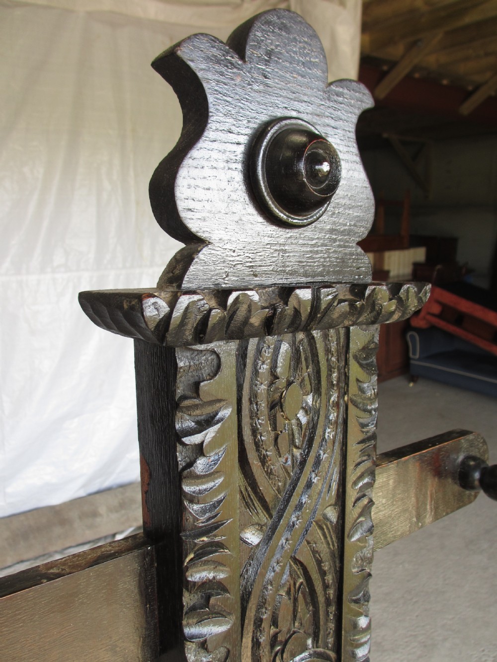 An antique Victorian dark oak hall stand featuring intricate carved patterns, turned coat pegs, a central narrow mirror, fretted base detailing, and integrated umbrella drip trays. View VIII