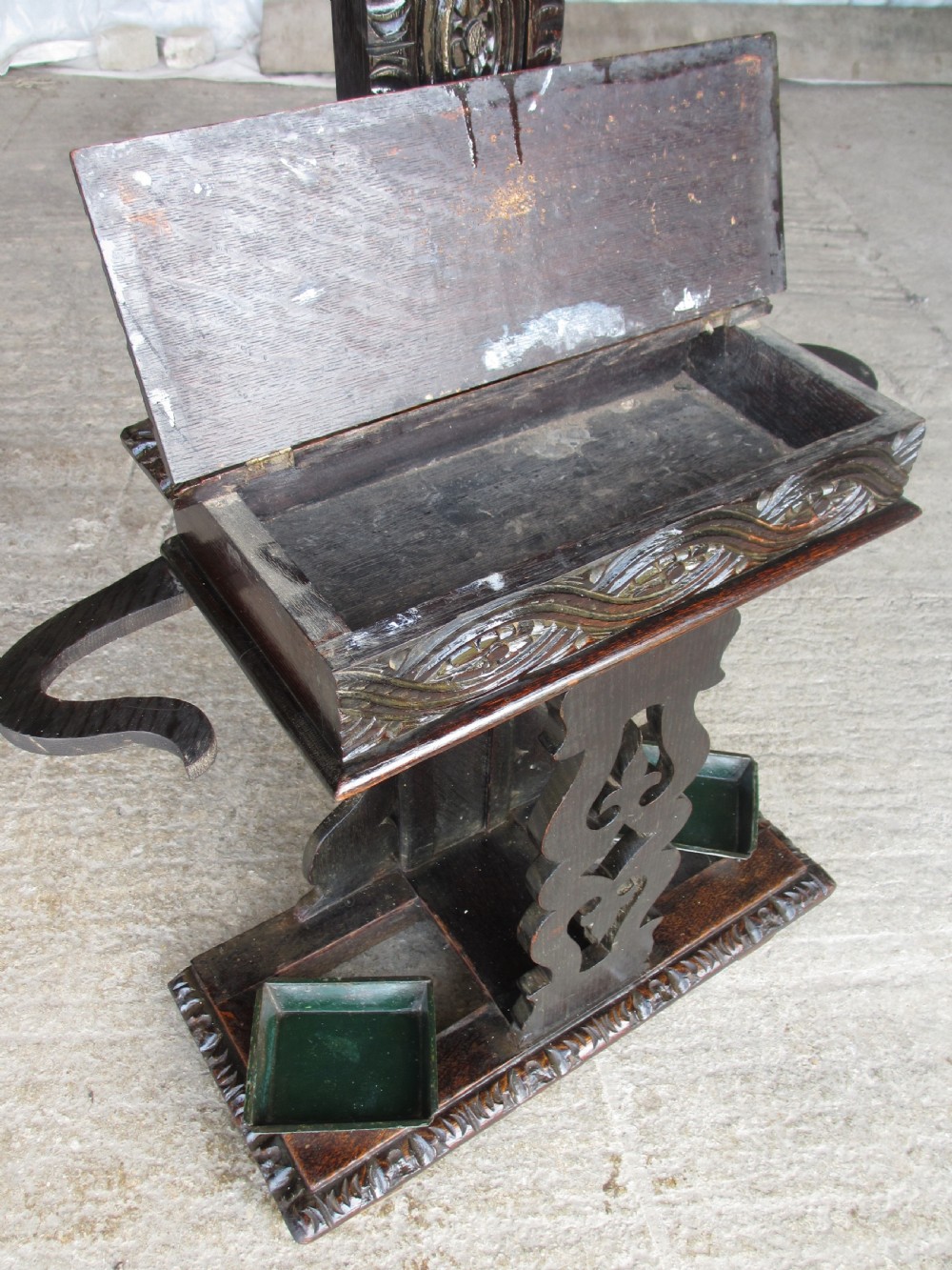 An antique Victorian dark oak hall stand featuring intricate carved patterns, turned coat pegs, a central narrow mirror, fretted base detailing, and integrated umbrella drip trays. View X