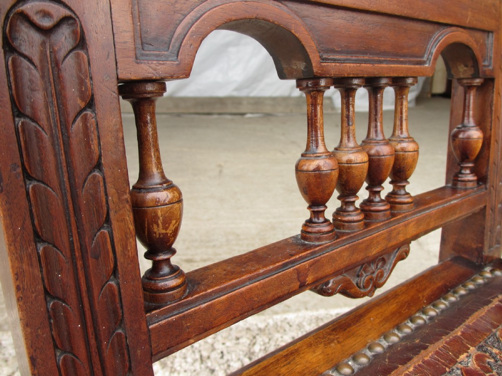 A set of Victorian dining chairs featuring embossed floral leather backrests and seats, brass top handles, turned front legs with castors, and studding detail. View IX
