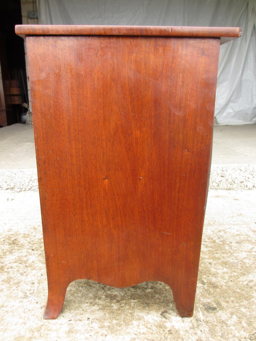 A Georgian flame mahogany bow-fronted pot commode featuring decorative string inlay, turned wooden knobs, and splayed bracket feet. View XI