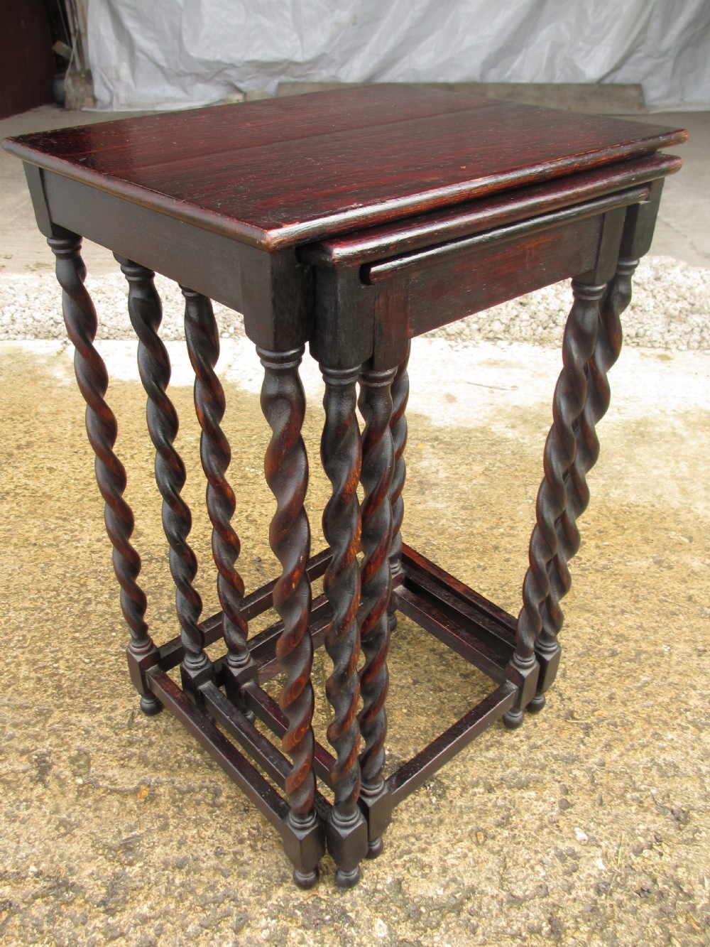 A nest of three dark oak square-topped side tables featuring carved barley twist legs and low stretchers. View II