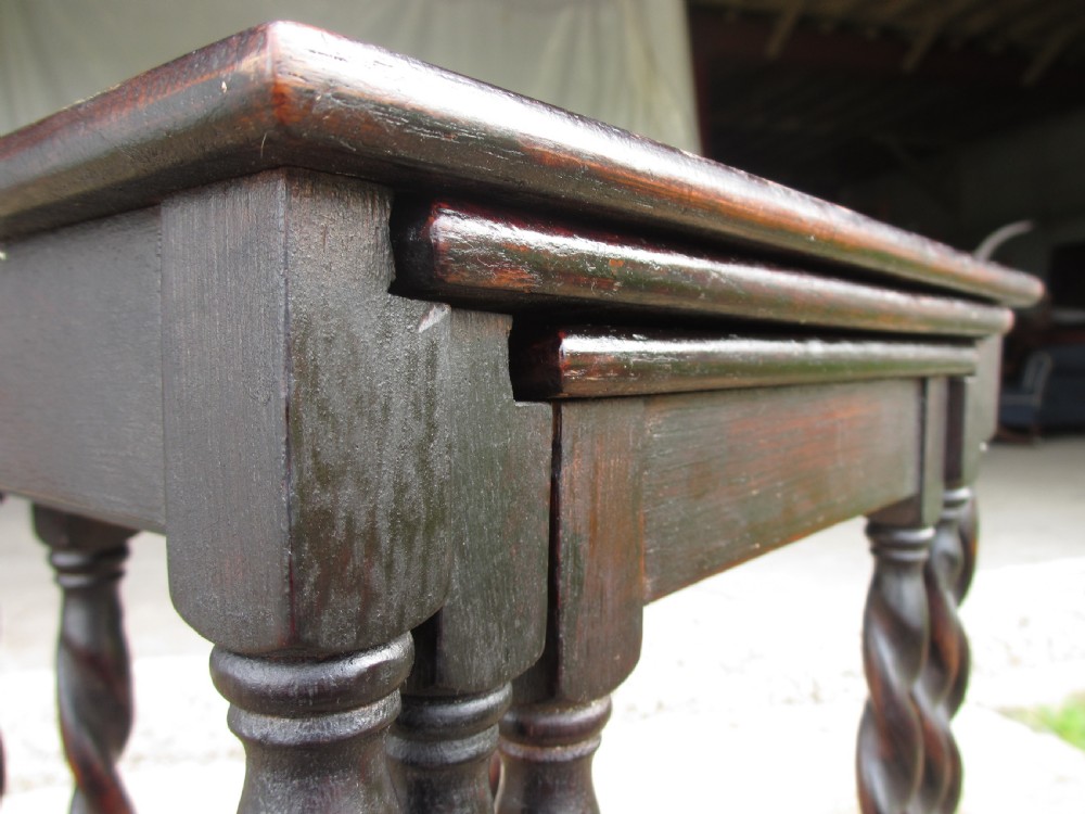 A nest of three dark oak square-topped side tables featuring carved barley twist legs and low stretchers. View V