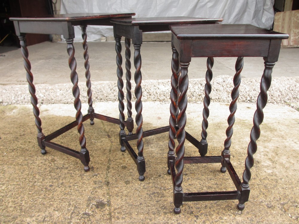 A nest of three dark oak square-topped side tables featuring carved barley twist legs and low stretchers. View VI
