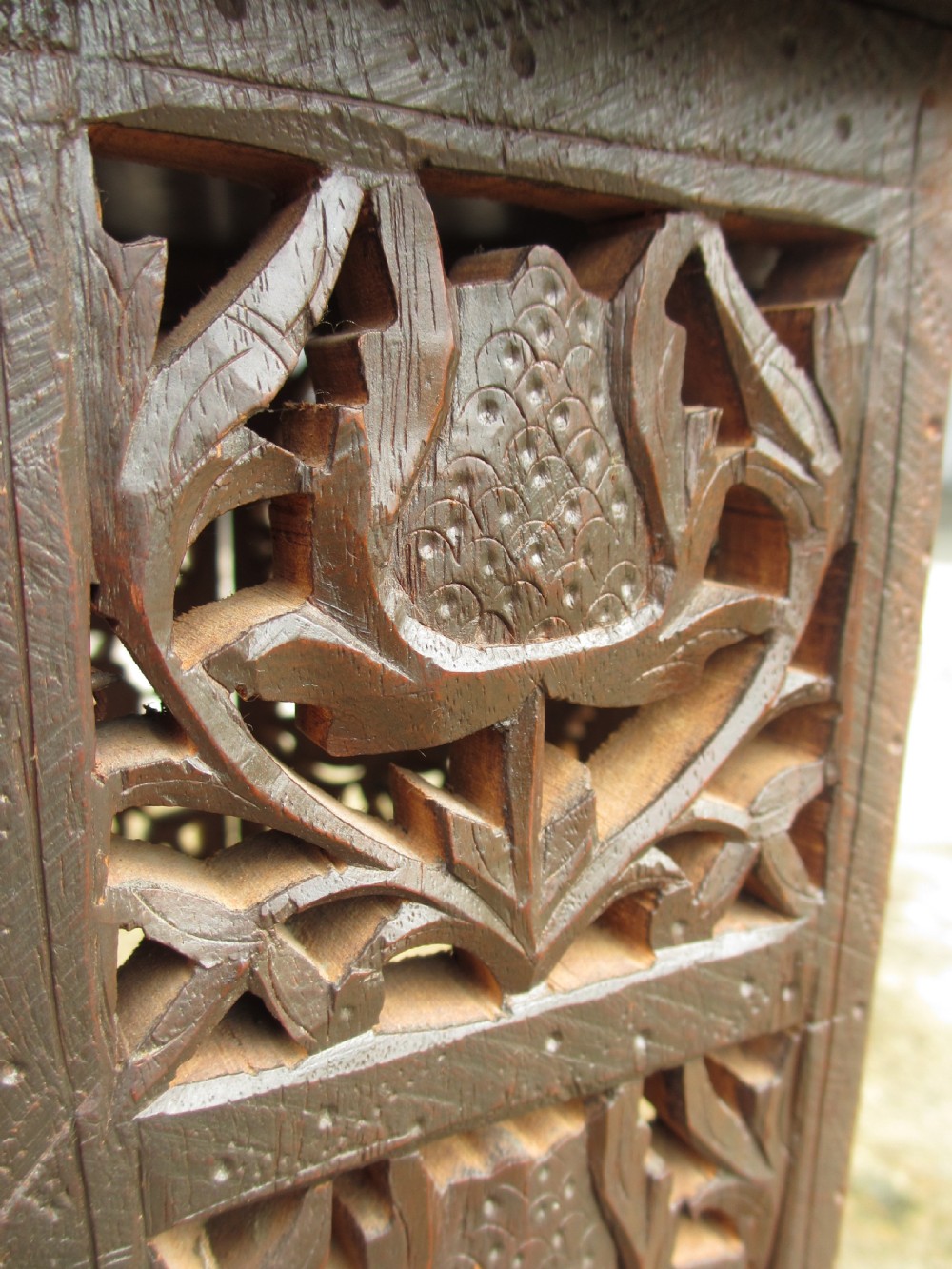 A pair of 19th-century Anglo-Indian padauk wood occasional tables featuring circular tops with deep foliate carvings and central bone inlay set upon collapsible octagonal pierced fretwork bases. View VII