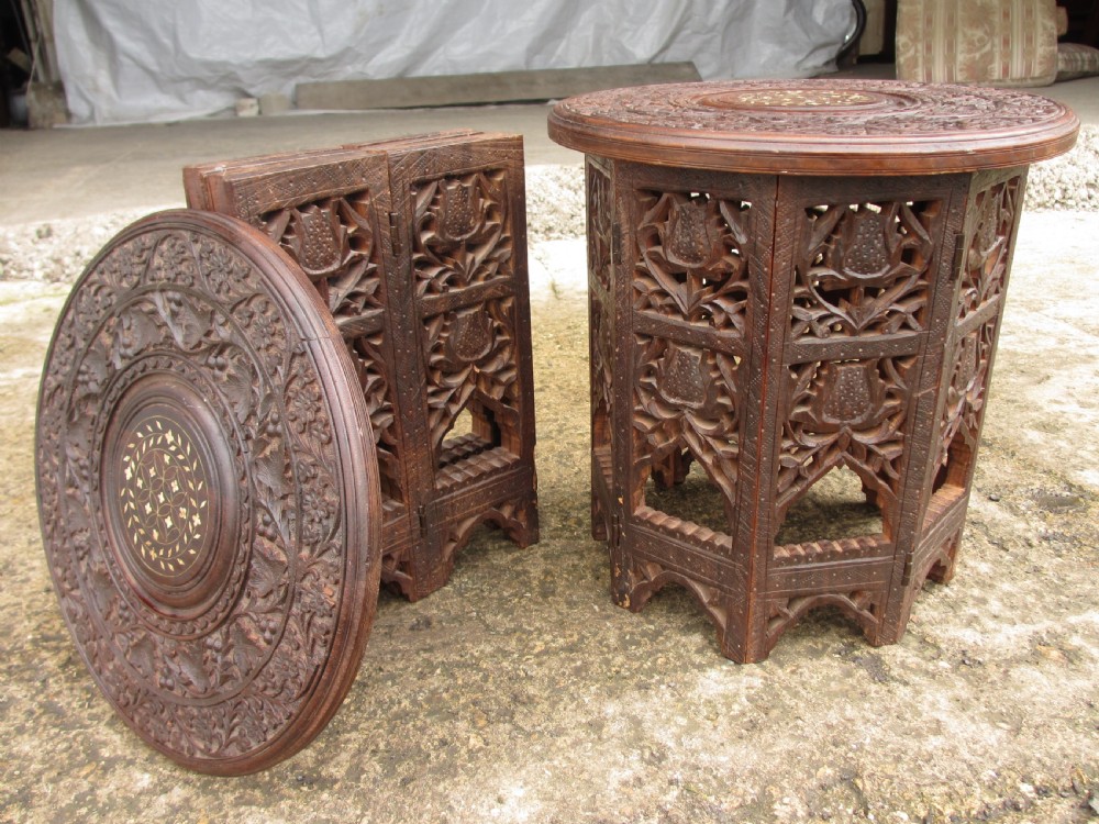 A pair of 19th-century Anglo-Indian padauk wood occasional tables featuring circular tops with deep foliate carvings and central bone inlay set upon collapsible octagonal pierced fretwork bases. View XII