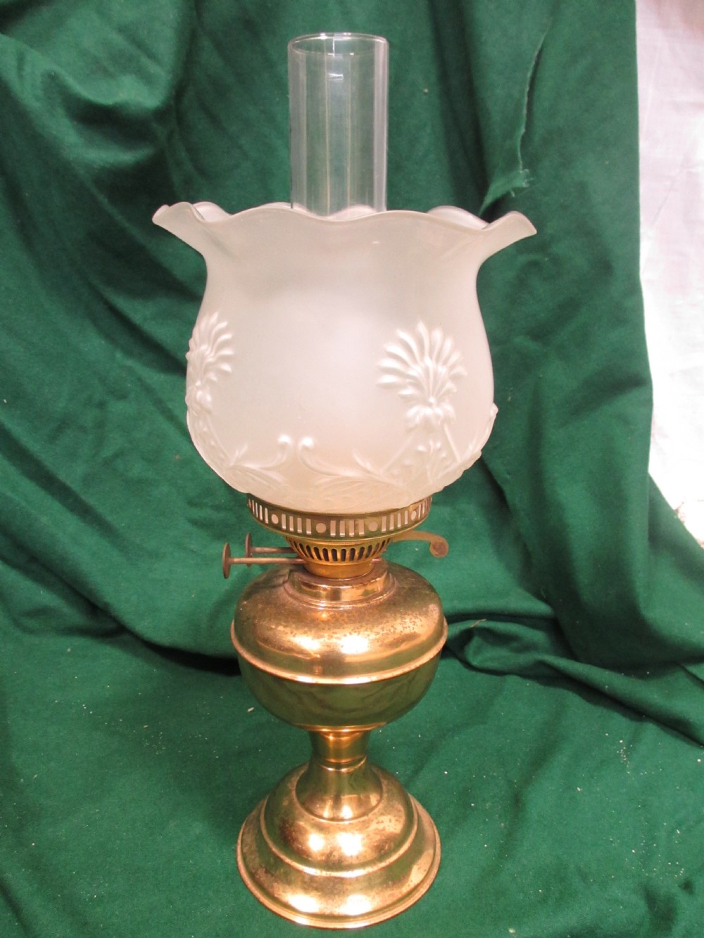 A Victorian oil lamp featuring a brass pedestal base and reservoir, a frosted glass shade with a frilled rim and floral relief patterns, and a clear glass chimney. View II