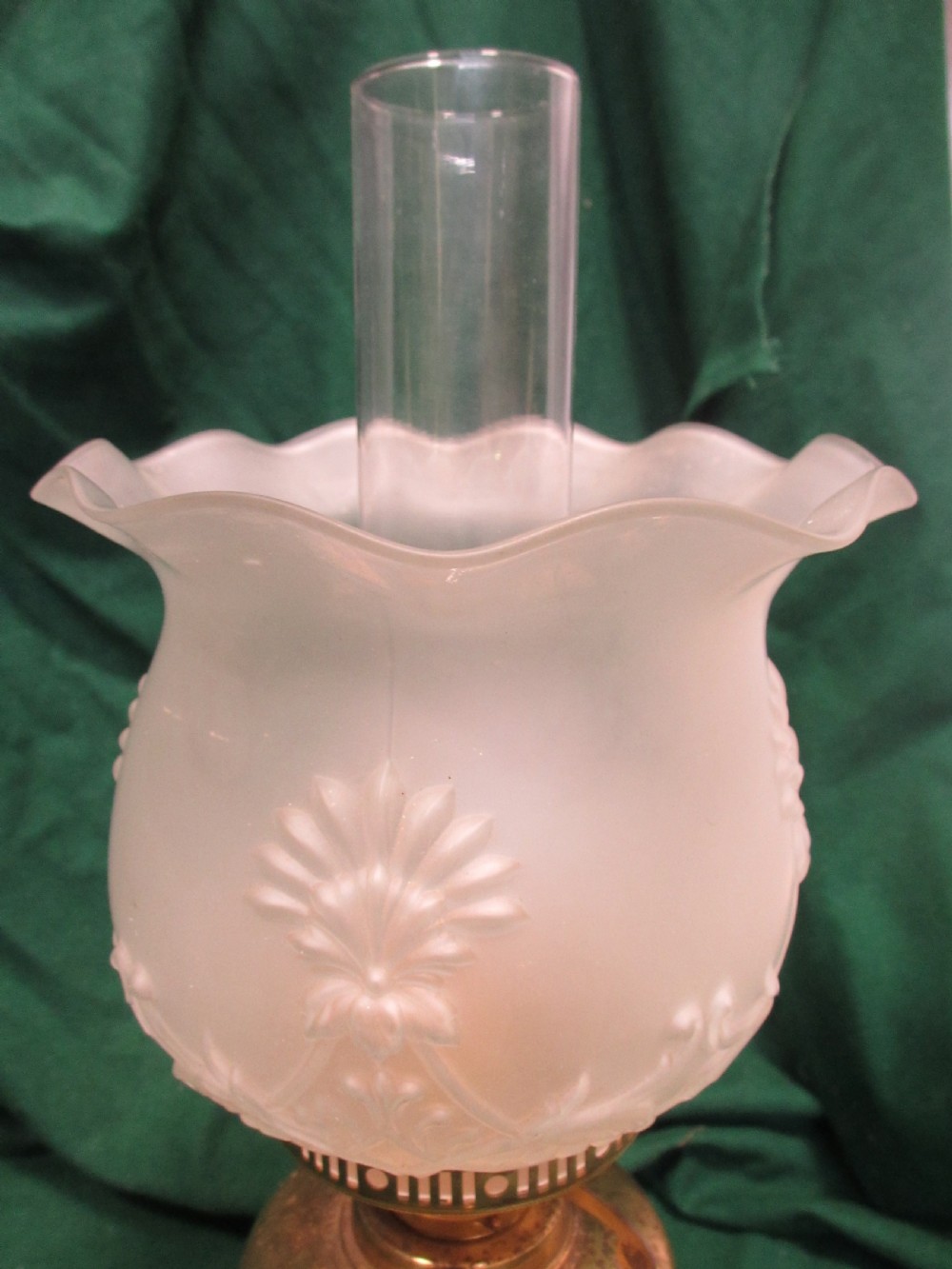 A Victorian oil lamp featuring a brass pedestal base and reservoir, a frosted glass shade with a frilled rim and floral relief patterns, and a clear glass chimney. View III