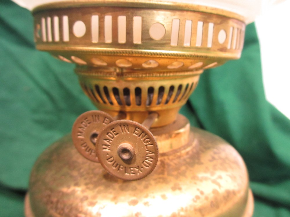 A Victorian oil lamp featuring a brass pedestal base and reservoir, a frosted glass shade with a frilled rim and floral relief patterns, and a clear glass chimney. View VI