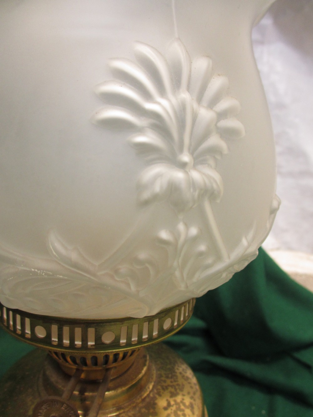 A Victorian oil lamp featuring a brass pedestal base and reservoir, a frosted glass shade with a frilled rim and floral relief patterns, and a clear glass chimney. View VII