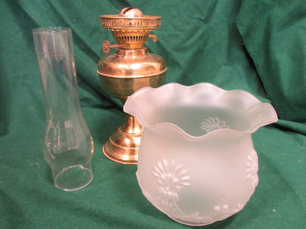 A Victorian oil lamp featuring a brass pedestal base and reservoir, a frosted glass shade with a frilled rim and floral relief patterns, and a clear glass chimney. View IX