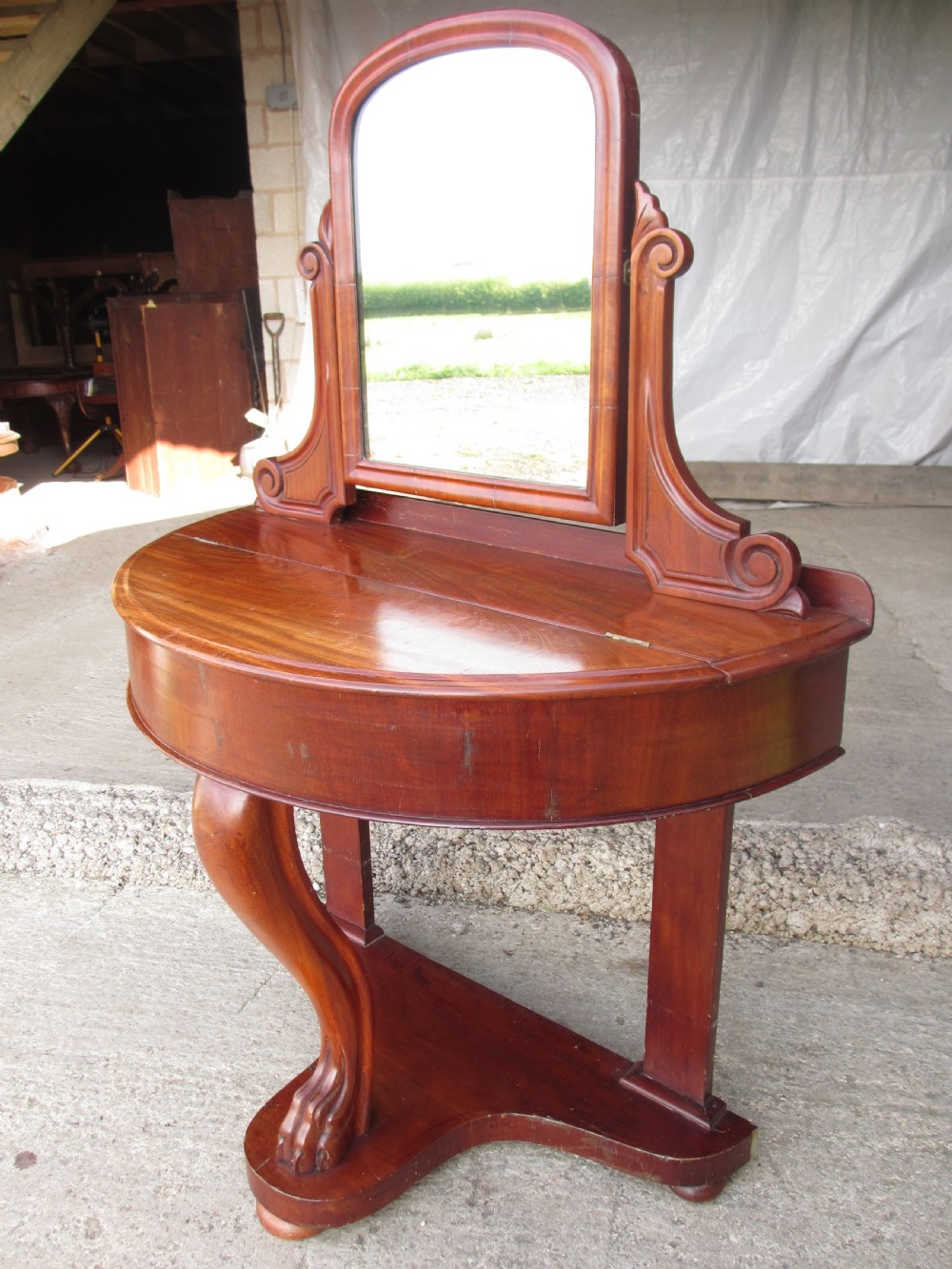Victorian mahogany demi-lune dressing table featuring an arched swing mirror flanked by scrolled supports and a central carved cabriole front leg. View IV